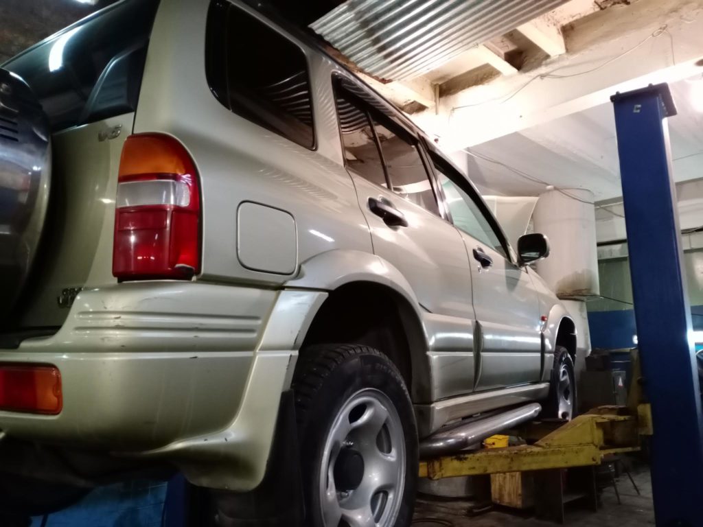 Задняя часть Suzuki Grand Vitara на подъёмнике: дверь багажника, фонарь и заднее колесо — автосервис автотело.рф